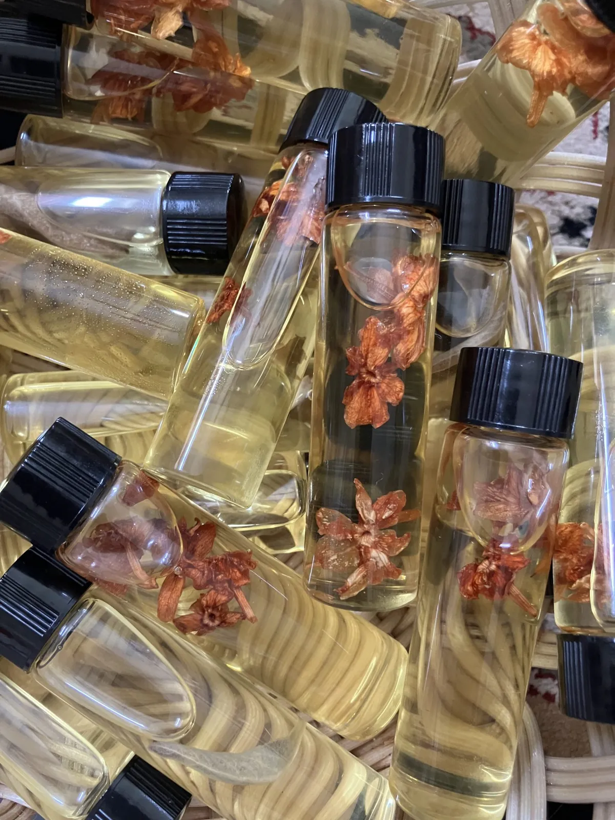 Basket of hand-made ritual oils with dried flowers in glass vials